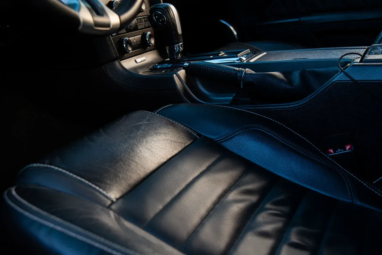 An immaculate black-leather car cabin at night