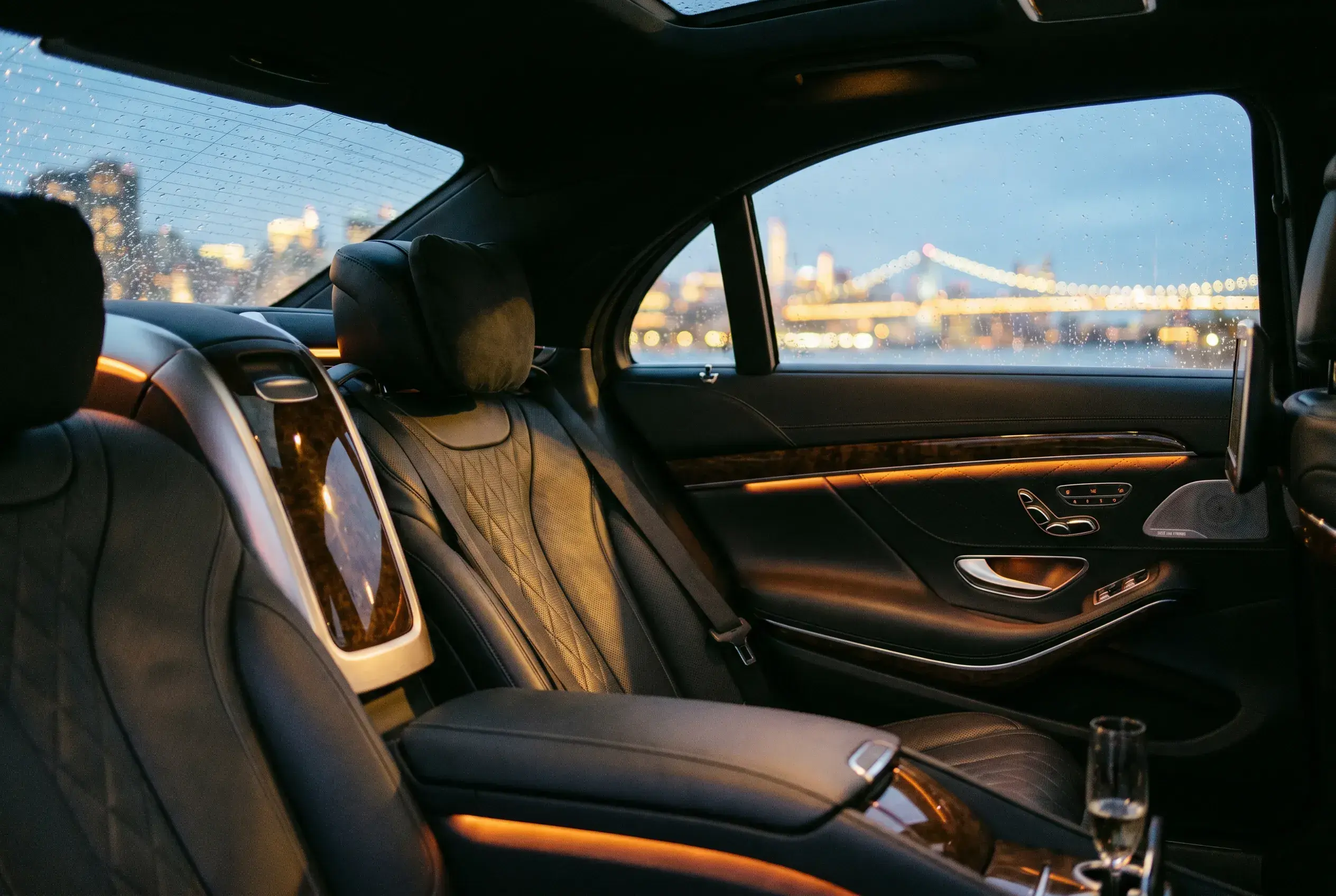 Rear cabin interior — quilted black leather, warm ambient light