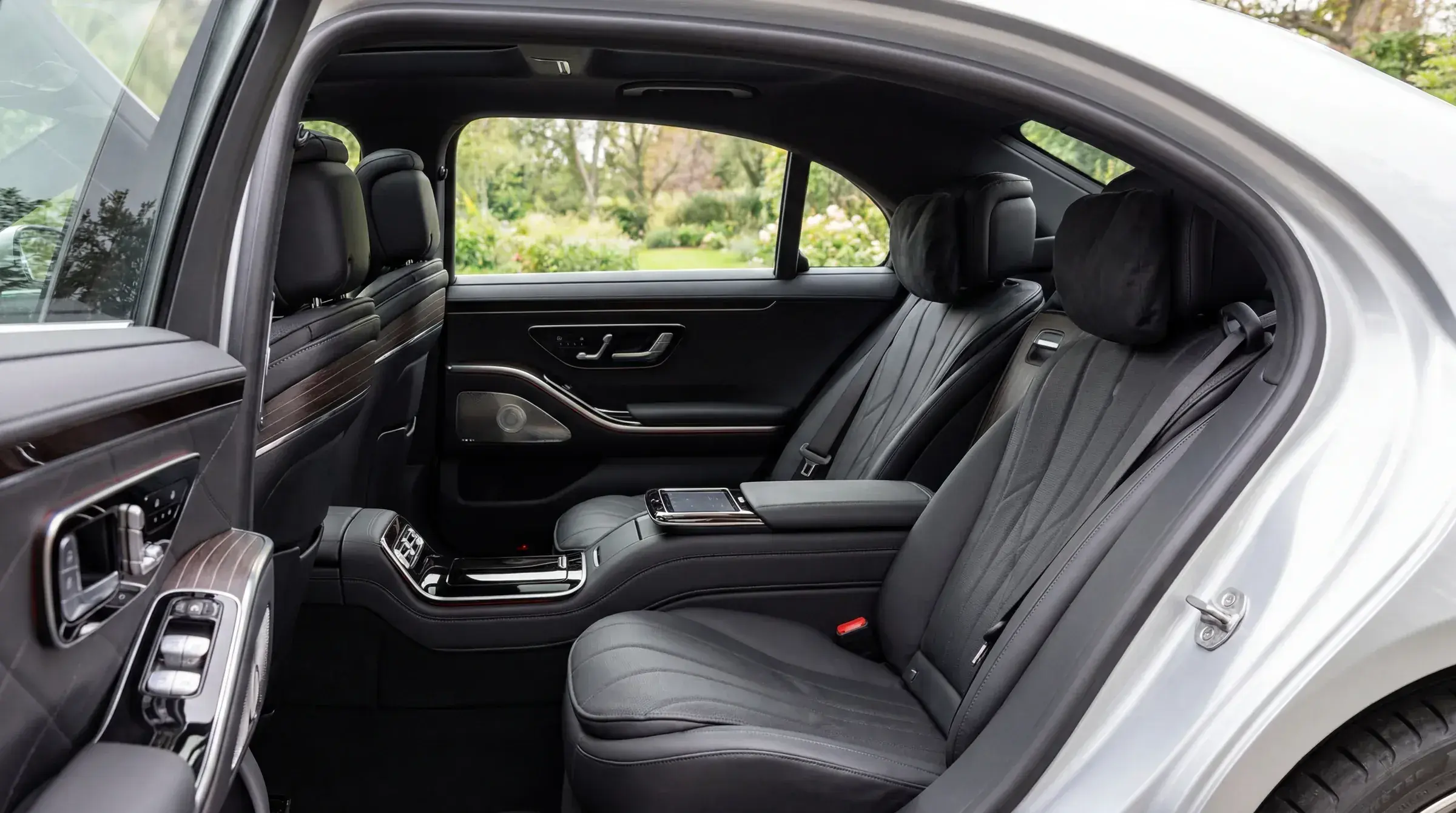 Mercedes-Benz S-Class rear passenger compartment — black leather seats, soft daylit view through the windows