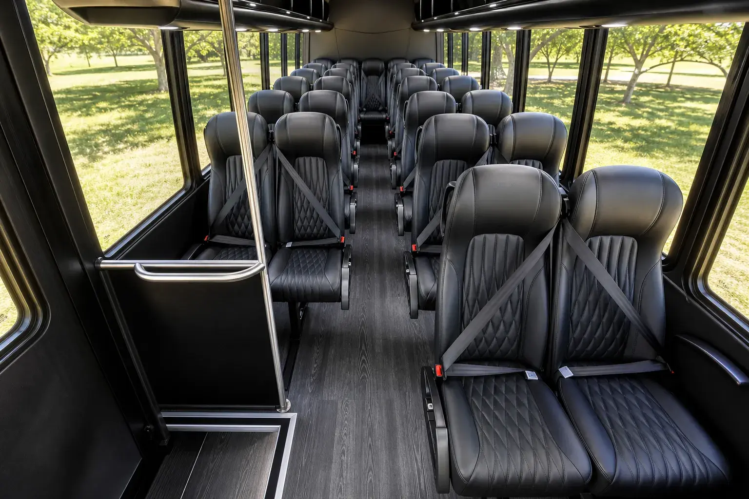 Luxury mini coach interior — quilted black leather coach seats facing forward toward the cockpit