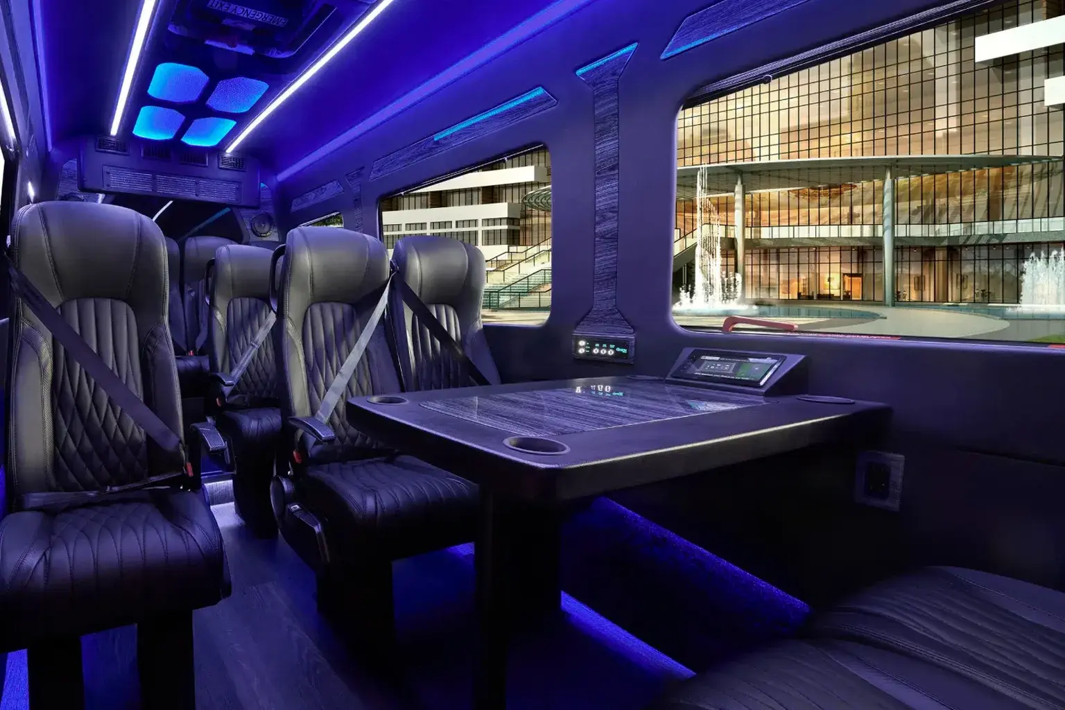 Luxury Mercedes-Benz Sprinter executive cabin — forward-facing black quilted-leather captain chairs around a center table, soft blue ambient lighting