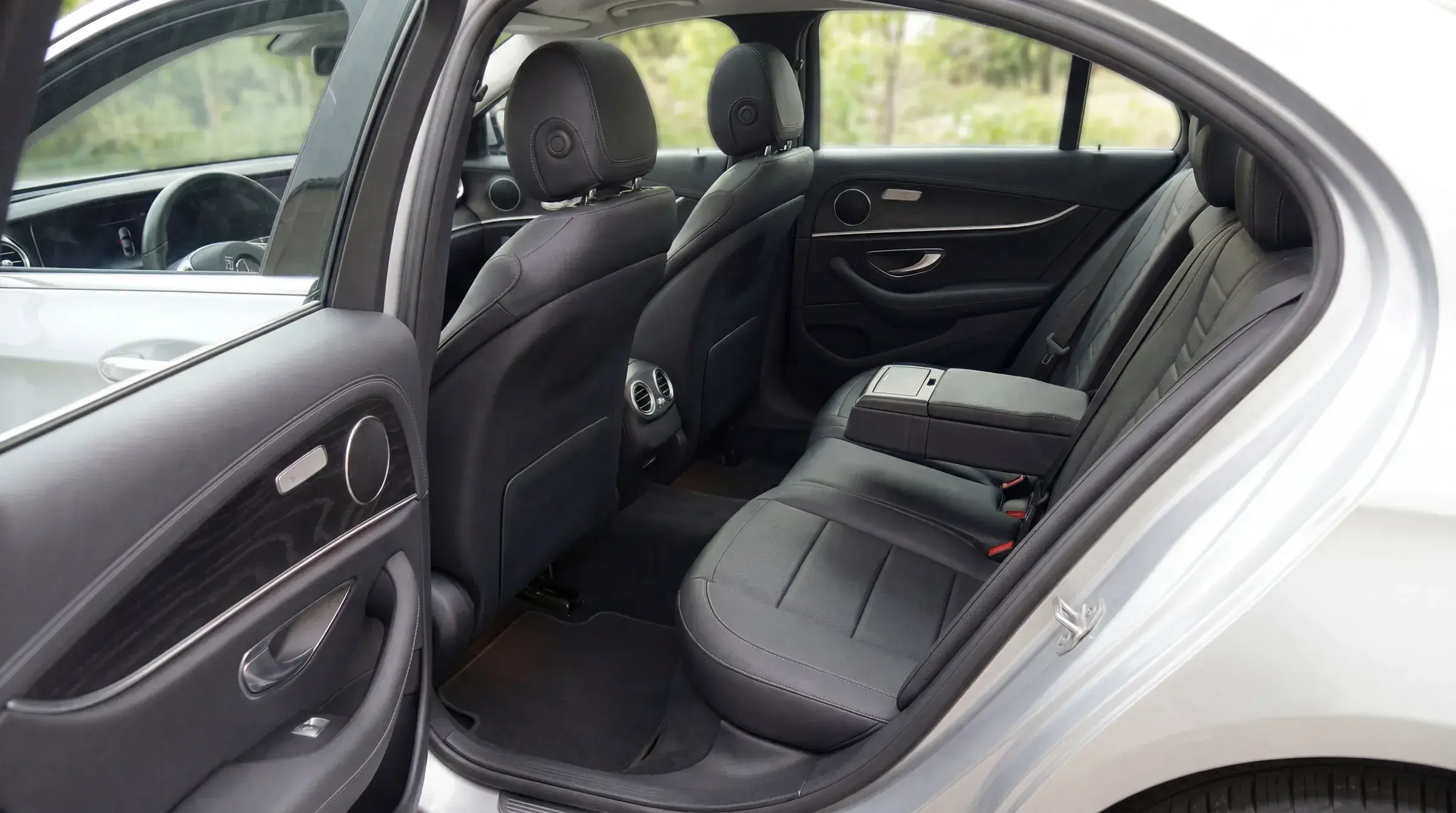 Mercedes-Benz E-Class rear passenger compartment — black leather seats, soft daylit view through the windows